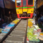 Vlak jede těsně nad ovocem a zeleninou, Maeklong Railway Market, Bangkok